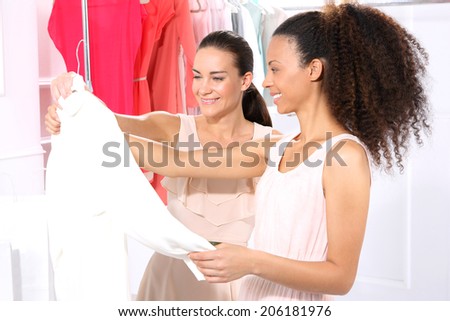 Sale, women shopping .Two women shopping in boutique clothing, mulatto and Caucasian