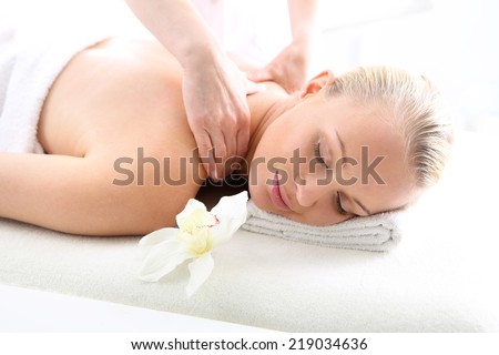 Therapeutic massage, heals the pain and relaxes .Attractive blonde woman in the office spa, relax with a massage