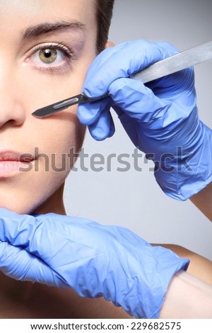 Plastic surgery, a woman in the clinic of aesthetic surgery.Caucasian woman during surgery using a scalpel