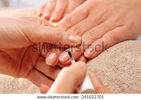 Nail Polish,  woman to a beautician.Treatment hand and nail care, the woman to a beautician for a manicure.