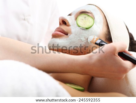 Cleansing mask, mask with green clay, relax in the spa  Cosmetic procedure woman\'s face in the mask mitigating and cucumber slices on eyes