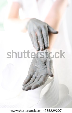 Manicured hands in the summer. Women\'s hands during surgery cosmetic hands with the applied mask with green clay.