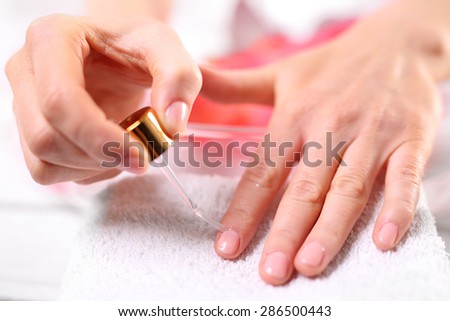 Nail painting. Woman paints the nails cuticle oil and nail