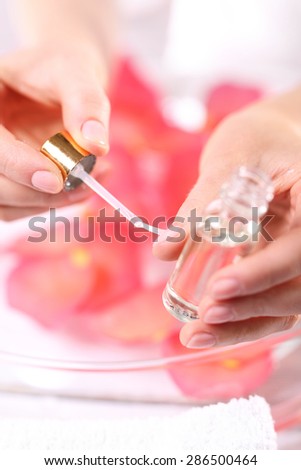 Manicure, natural beauty of the women\'s hands. Woman paints the nails cuticle oil and nail
