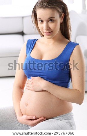 Preparation for childbirth at home. Pregnant woman sitting on the ball in oczekowaniu at birth.