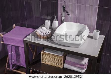 detail of a modern bathroom with sink and accessories, bathroom cabinet and blue bathroom tiles