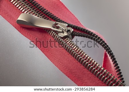 a red zipper opened to a gray surface