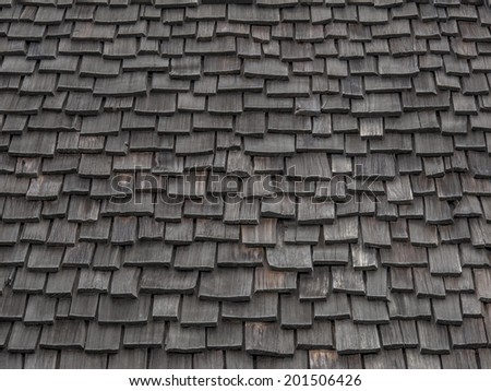 Old weathered wooden shingles continue being used as roofing material.