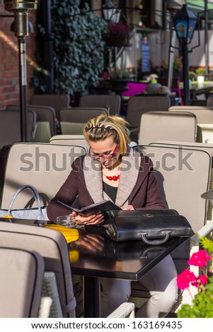 Young pretty girl is waiting for somebody in  restaurant