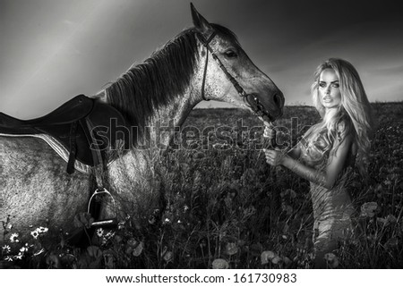 Black and white photo of attractive woman posing with horse.