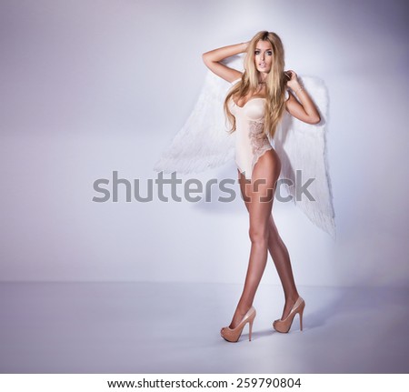 Sexy blonde beautiful woman posing with angel wings.