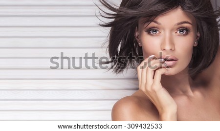 Closeup beauty portrait of sexy brunette woman with long lashes and short hair. Girl looking at camera. Perfect skin. Beautiful eyes. Studio shot.