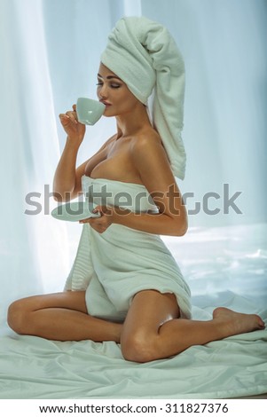 Beautiful attractive woman drinking coffee. Girl with white towel on head. Morning photo.