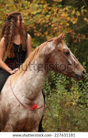 Amazing girl riding a horse without bridle in autumn