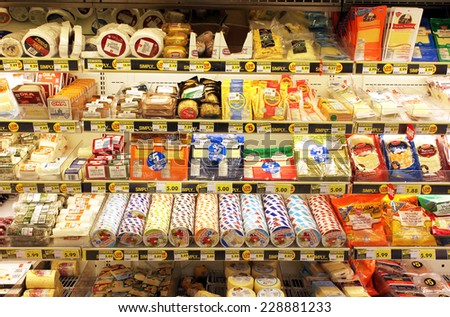 TORONTO, CANADA - OCTOBER 31, 2014: Different types of cheese on shelves in a grocery store. Hundreds of types of cheese are produced by various countries with different styles, textures and flavors.