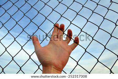 Hand grabs the fence