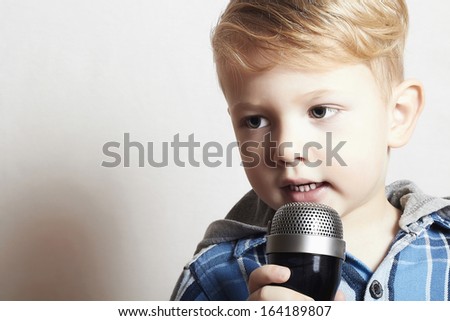 little boy singing into a microphone. child in karaoke. fashionable singer.your text here