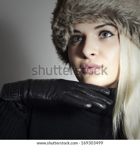 Beauty Fashion blond Girl in Fur Hat. Beautiful Blond Woman in Black Leather Gloves. Winter Fashion