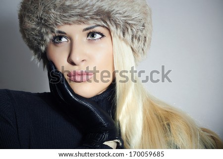 Close-up Portrait of Beautiful Blond Woman in Fur Cap. Beauty Girl. Winter Style