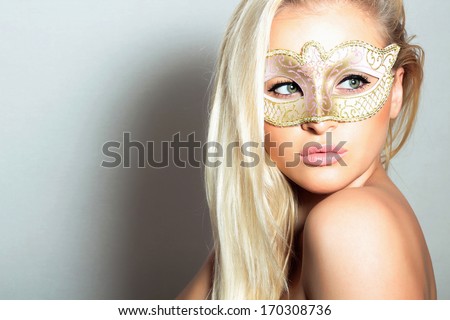 Beautiful Blond Woman in a Carnival Mask.Holiday Masquerade. Sexy Girl. Beauty & Fashion
