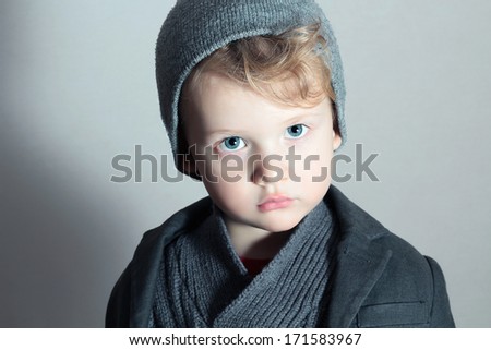 Fashionable Little Boy in Cap.Stylish Kid.Fashion Children.Handsome blond kid.Winter