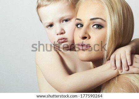 Young Beauty Mother Hugging Child. Beautiful Blond Woman with Little Son. Happy Family