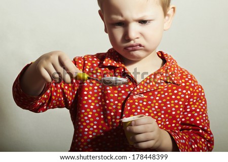 Little Handsome Boy eats Yogurt. Child with Spoon. Milk Food. Don\'t like it