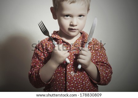 Little Handsome Boy with Fork and Knife. Hungry Child. Beauty and Food. Want to eat