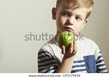 Child holds the apple.Little Handsome Boy with green apple. Health food. Fruits. Enjoy Meal. 4 years old