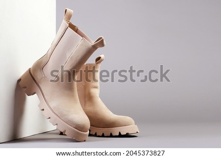 Trendy boots with wooden wall. fashion female shoes still life. stylish chelsea boots ストックフォト © 