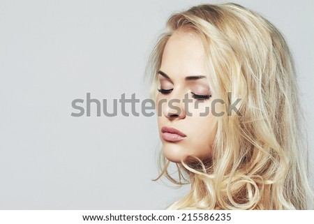 Fashion portrait of young beautiful woman.Sexy Blond girl. Gray Background.Your text here.closed eyes