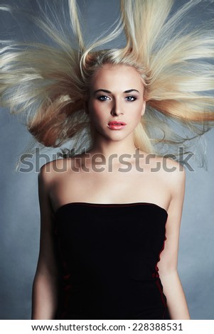beautiful woman in black dress. Sexy blond girl. Beautiful healthy hair.Beauty salon.flying hair