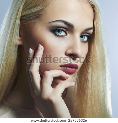 Blond woman with manicure.Beautiful girl model with blue eyes lens