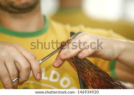 a woman cutting hair, Hairdresser cutting hair in salon closeup