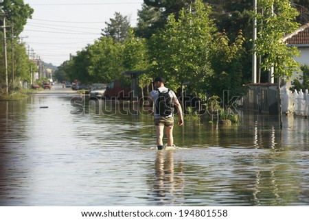 SERBIA, OBRENOVAC - MAY 21: A man walks through water in Obrenovac under water. The water level of Sava River remains high in worst flooding on record across the Balkans on may 21, 2014