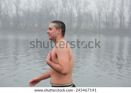 BELGRADE, SERBIA - JAN 19, 2015: Swimmer before jumping in the cold waters. Orthodox Christians celebrate Epiphany with traditional ice swimming in Belgrade.