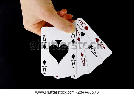 croupier player holding in hand card ace of spades four of a kind on black background