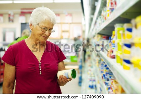 Senior woman checking label on jar