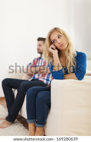 Crying woman sitting with her boyfriend in the background