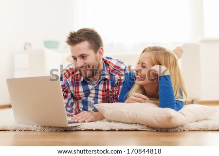 Happy couple surfing the net at home