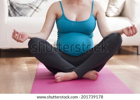 Close up of pregnant woman during yoga at home