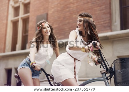 Retro portrait of two friends riding tandem bicycle