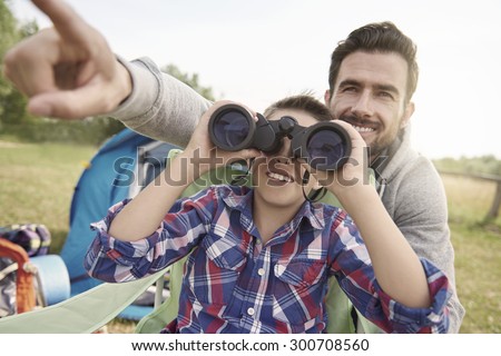Father showing son the world via binoculars