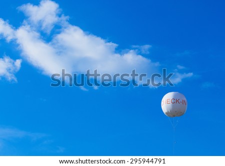 small balloon with check-in in front of sky and clouds