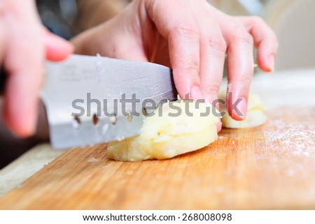Preparing russian traditional salad Olivier, chopping potato