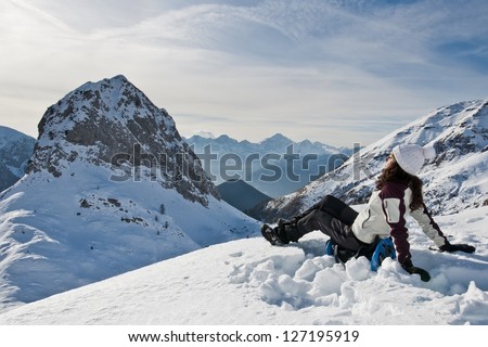 Sunbathing on the snow (B): A girl sunbathing and relaxing on the top of a mountain in the Italian Alps after a strenuous hike with snow shoes.
