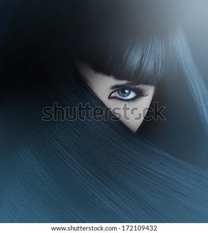 mysterious brunette with hair covered face and aquamarine eyes