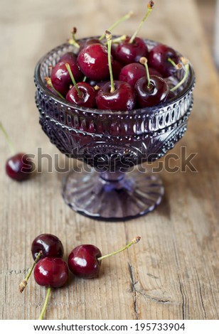 crystal bowl of cherries on a wooden table