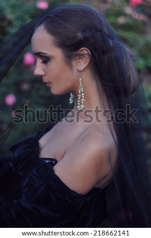 Young widow with closed eyes wearing black veil