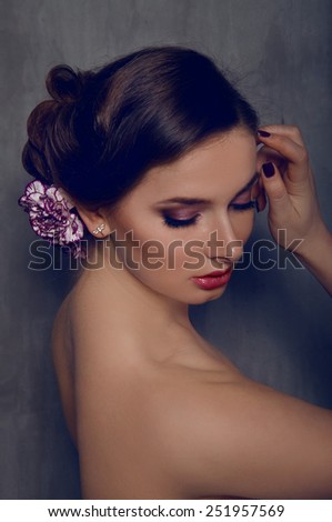 Beautiful woman with carnation flower in her hair with smokey eyes makeup